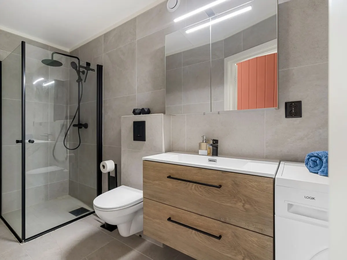 Wall hung wood front vanity in a modern bathroom with a glass shower