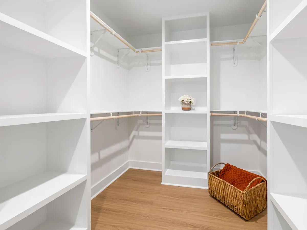 White walk-in closet system with empty shelving and hanging rods