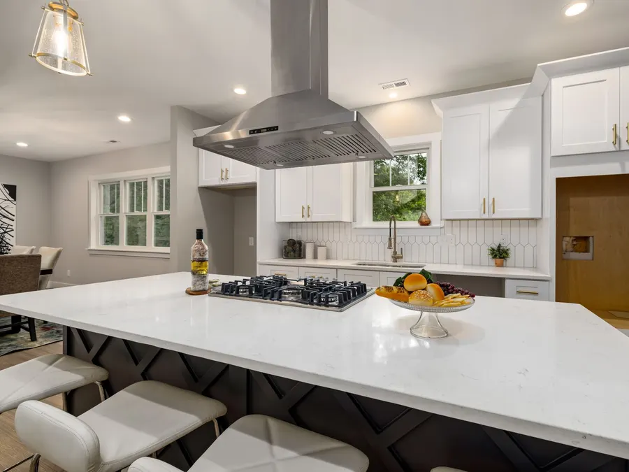 White custom kitchen cabinets with an island and quartz countertop