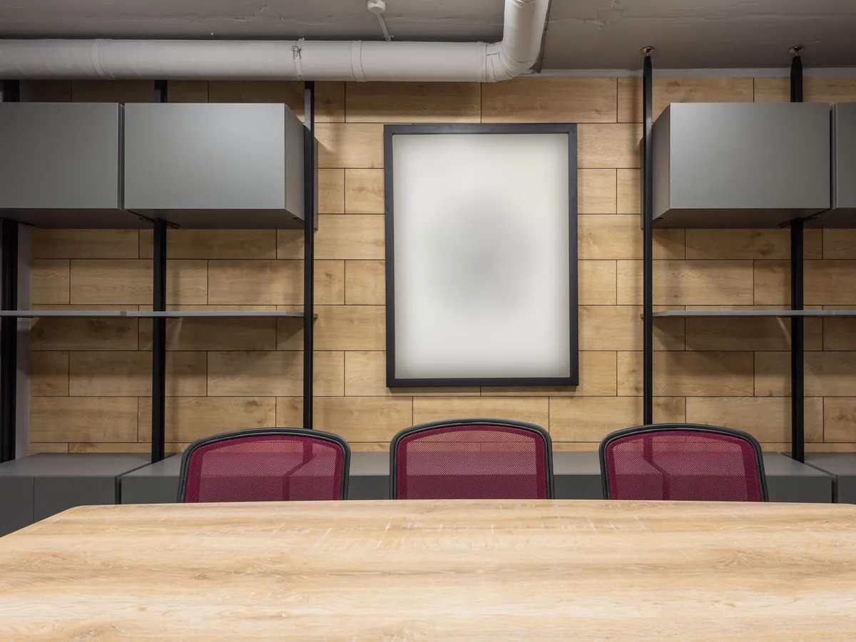 Conference room wall storage with gray upper cabinets above a low credenza run