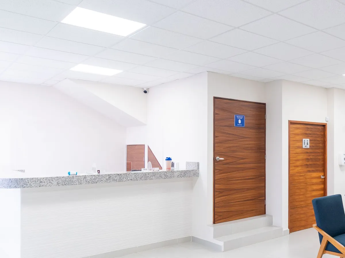 Reception counter with a granite top beside wood office doors