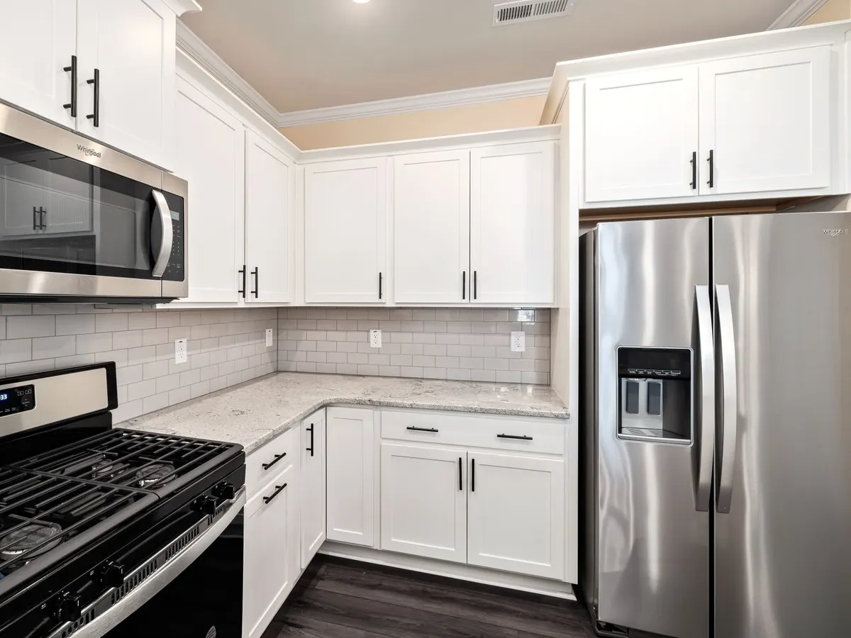 White shaker cabinet doors and drawer fronts beside stainless appliances