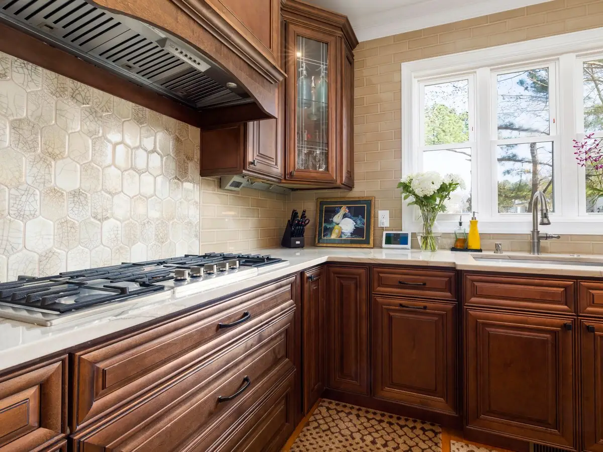 Glazed cherry traditional kitchen with a hex tile backsplash
