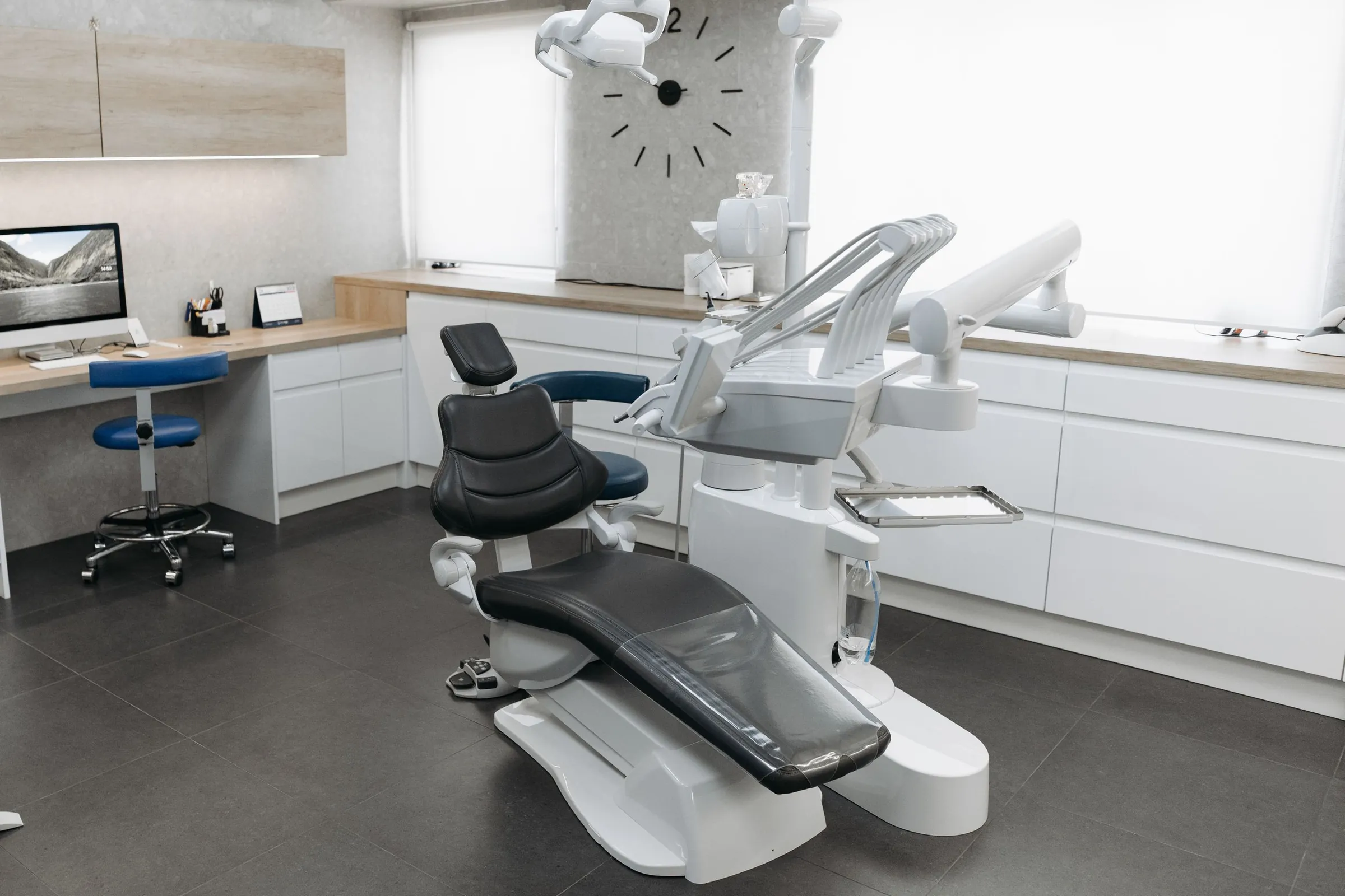 Dental operatory with white slab-front base cabinets, a wood-look countertop, and wood-look upper cabinets