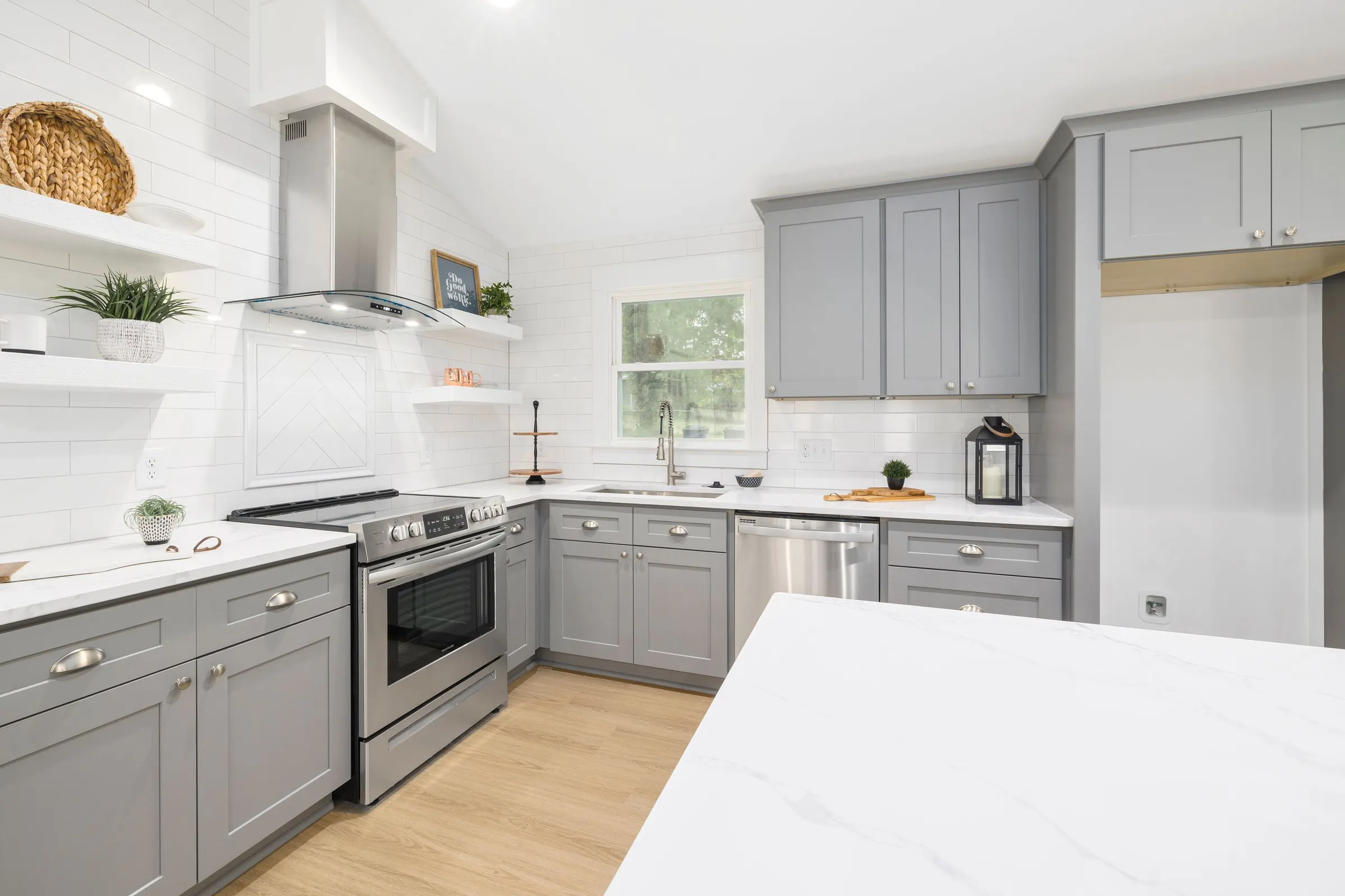 Gray shaker kitchen with a range hood and marble look island