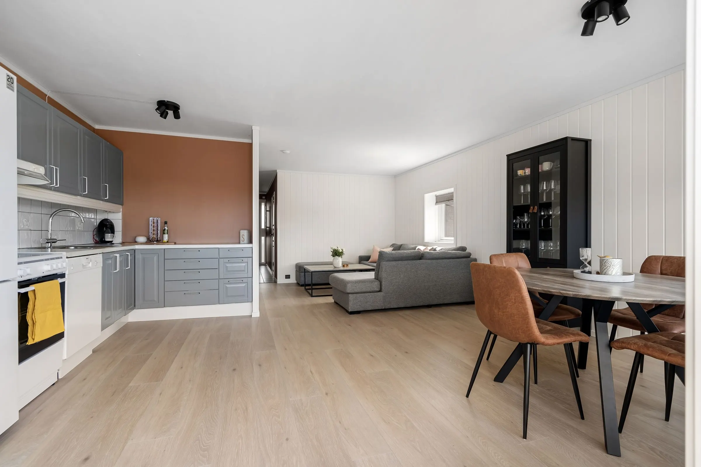Refreshed kitchen with gray cabinets opening to a living room